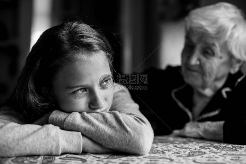 一个哭泣的小女孩被她祖母安慰着图片