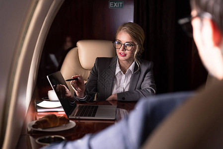 业务经理在飞机上使用笔记本电脑图片