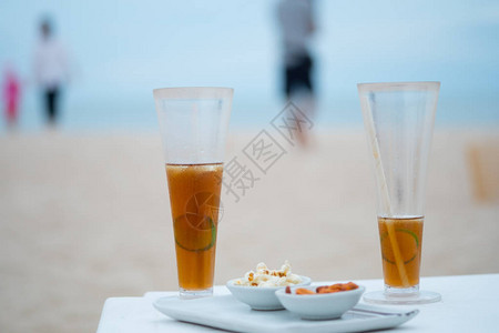 在海景背的海滩上放着一杯高冷冰茶和柠檬片豪华假期的概念图片