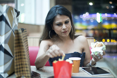 在现代商场购物后时装妇女喝咖啡图片