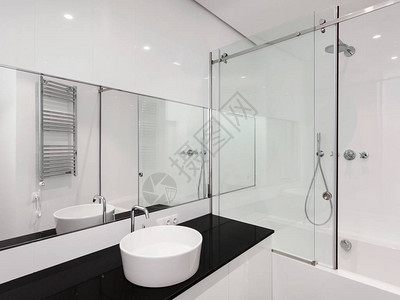 有白色现代室内设计的房子新公寓浴室墙上的浴缸面盆淋浴大镜子和镀铬银加热器图片