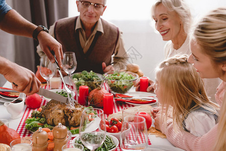 家人在感恩节餐桌边吃着美味的火鸡的父亲图片