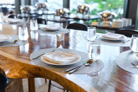 餐厅的餐具摆设木桌上装饰优雅的桌子瓷盘眼镜餐巾图片