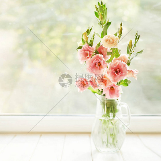 以窗户为背景的桌子上放着洋桔梗花的瓶图片
