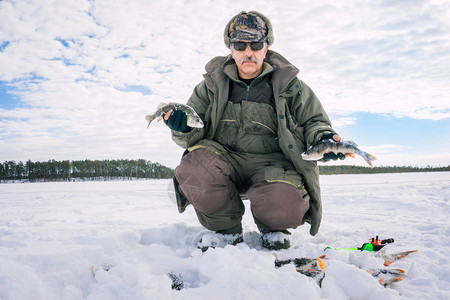 一个渔夫拿着冰钓大鱼贝图片