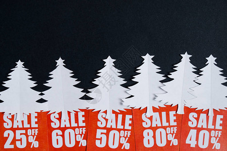 纸上写着圣诞树和红色贴现卡的黑纸什么人圣诞销售概念平图片