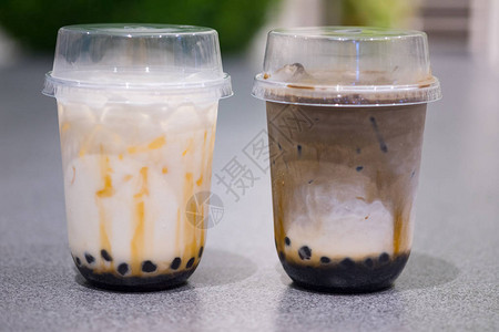 奶茶,背景两杯hojicha奶茶新鲜牛奶和泡boba加一层奶油酪泡沫背景