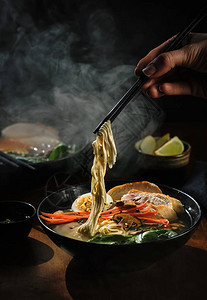 用筷子手拿拉面汤传统的亚洲美食图片