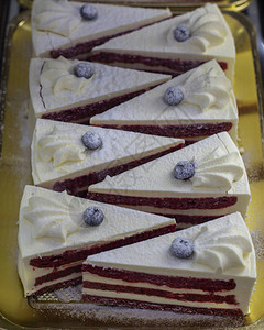 一块三角形的蓝莓浆果蛋糕配香草奶油用蓝莓和奶油卷发装饰的图片
