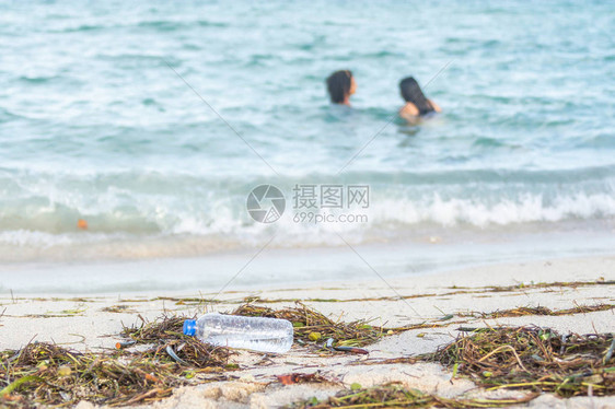 脏沙滩上空塑料水瓶的特写图像图片