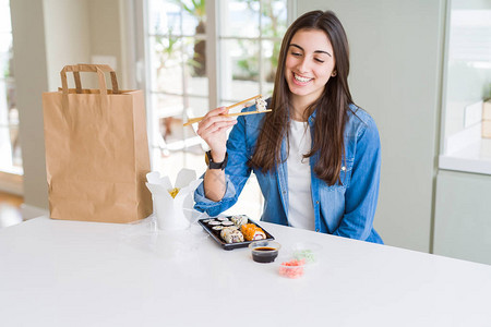 年轻女吃寿司豆类食品和面条图片