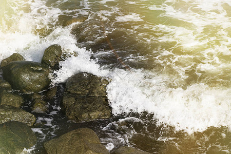 海浪拍打在石滩上形成了浪花图片