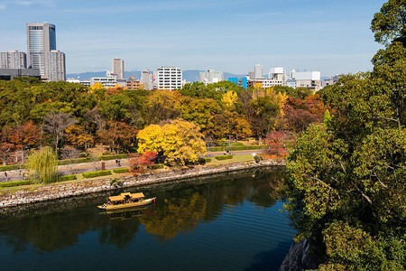 黄色旅游船环绕大阪城堡与日本瀑布树叶公园航行图片