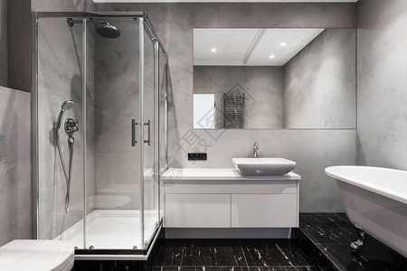 浴盆淋浴小屋大镜子和彩色银加热器或灰墙上的毛巾散热器背景图片