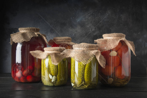 罐头发酵水果和蔬菜梅子黄瓜深木板玻璃罐中的番茄各种发酵类图片
