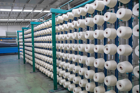 纺织厂整经机上的一组梭芯线锥在一家纺织厂制作纱球纺织工业纺织厂纺图片