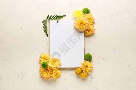 菊花枸杞在浅色背景上用鲜花和笔记本的美丽构图背景