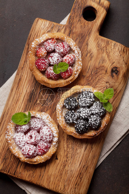 在木板上设置有浆果的甜蛋糕草莓覆盆子和黑莓图片
