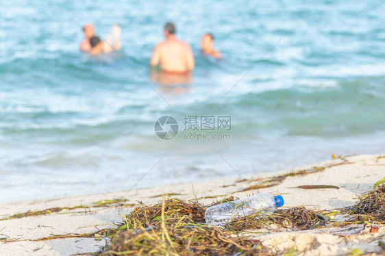 脏沙滩上空塑料水瓶的特写图像图片
