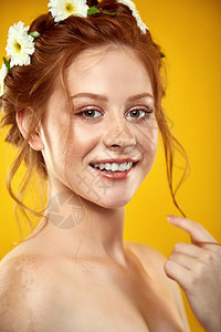 美丽的正红头发女孩的肖像头上戴着一杯甘菊冠假扮成黄色彩图片