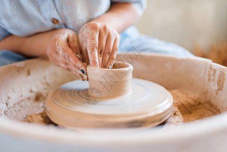 女陶工在陶轮上制作锅塑造一个碗的妇女手工陶瓷艺图片