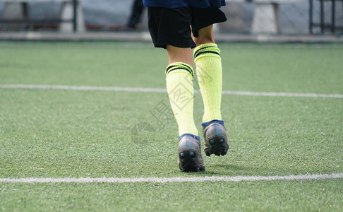 孩子的脚在足球场上练习跑步和移动青草足球练习场上的青年图片