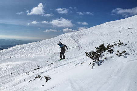 滑雪者在新鲜的白雪山上滑雪和跳跃图片