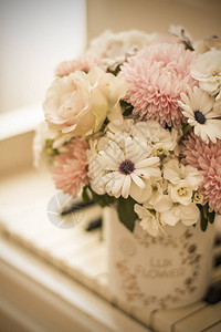 白色钢琴上一个漂亮的盒子里的花束紫菀绣球花和雏菊的花图片