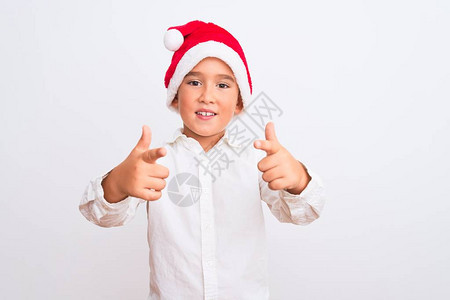 戴着圣诞老人帽子的漂亮男孩站在孤立的白色背景上图片