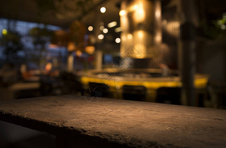 深色下咖啡馆餐厅模糊浅金色散景上的空木桌面图片