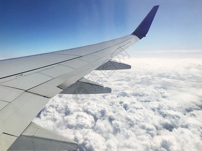 从机翼上的飞机照明器云层的天空中查看飞图片