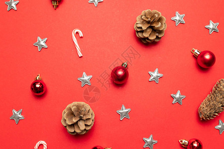 红色背景的顶部视图与松果圣诞装饰银星红色背景上的糖果手杖图片