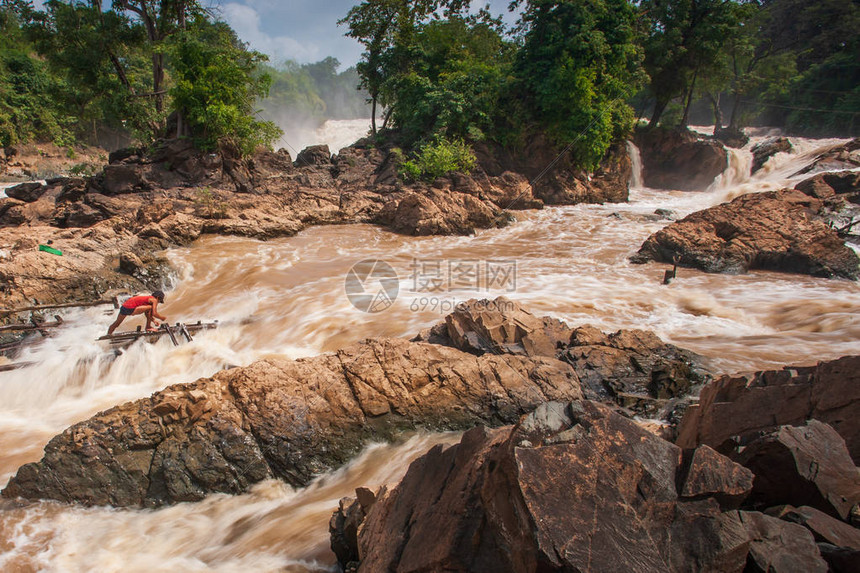 老挝渔民在湄公河KhonePhapheng瀑布的急流中孔帕彭瀑布是东南亚最大的瀑布雨季风景秀丽的瀑布老挝图片