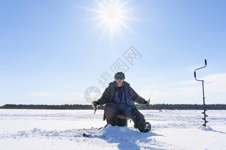 一个渔夫拿着冰钓大鱼贝图片
