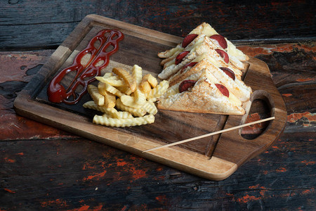 配有土耳其香肠苏库克和奶酪的三明治与薯条相隔绝的图片