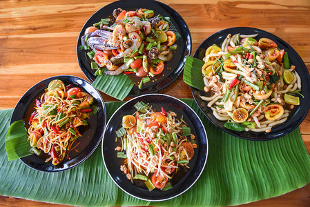 餐桌上供应木瓜沙拉盘子上供应青木瓜沙拉辣泰国菜图片