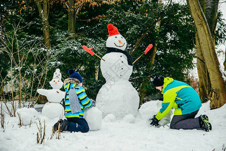 小可爱男孩做雪人滚大雪图片