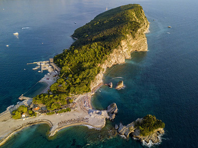 黑山的鸟瞰图夏威夷海滩遮阳伞和沐浴者以及清澈的海水锯齿状的海岸与陡峭的悬崖俯瞰着透明的大海野生自然和地中海图片