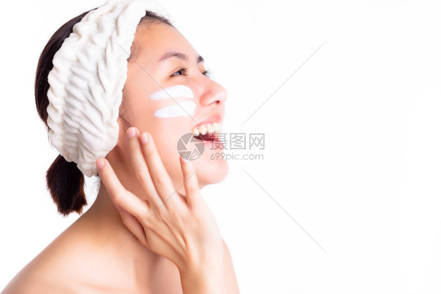 漂亮的女人把保湿乳液涂在脸上图片