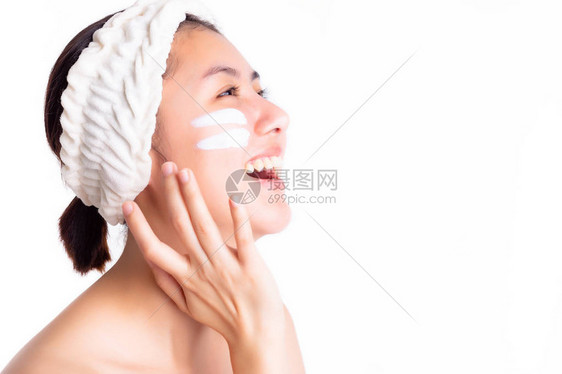 漂亮的女人把保湿乳液涂在脸上图片