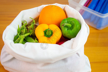 新鲜水果和蔬菜有机地装在木制桌上的生态布袋中图片