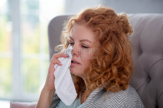 头晕有病的红头发女人拿着餐巾纸图片