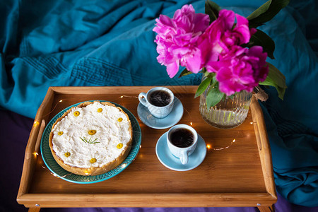在床上吃早餐窗边饼芝士蛋糕和木盘上两杯咖图片