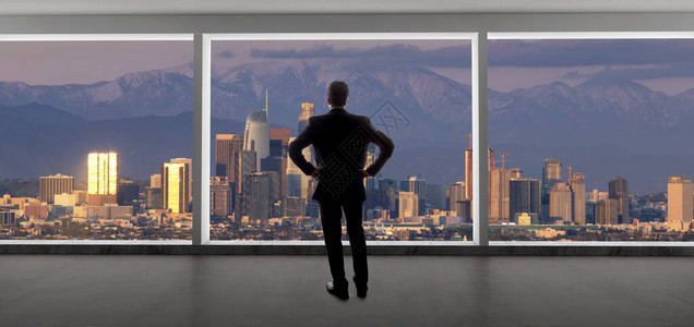 商人在办公室看着洛杉矶市中心的景色这个人看起来像在加利福尼亚工作的老板或区域经理背景显示了冬天白雪皑图片