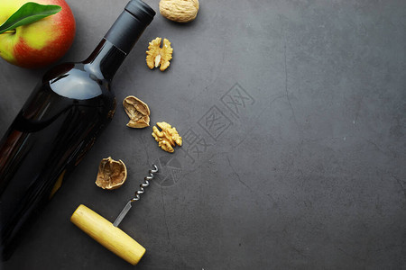 红酒在石头背景上葡萄酒杯和黑酒瓶奶油酪图片