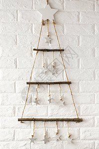 斯堪的纳维亚风格的木制时尚圣诞树以白色砖墙为背景简单约的圣诞和图片