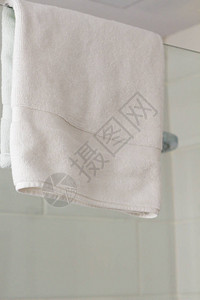 白色毛巾挂在淋浴室水疗酒店的玻璃墙上图片