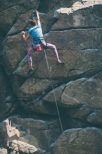 女孩攀登了花岗岩攀岩者在自然地形上列图片