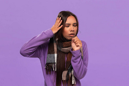 穿着毛衣的美籍女围巾被缠住了咳嗽在紫色背景上孤立无援图片