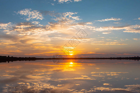 日落倒影泻湖在云层和蓝天之上的泻湖景观背景之上的美丽日落日落时有云图片